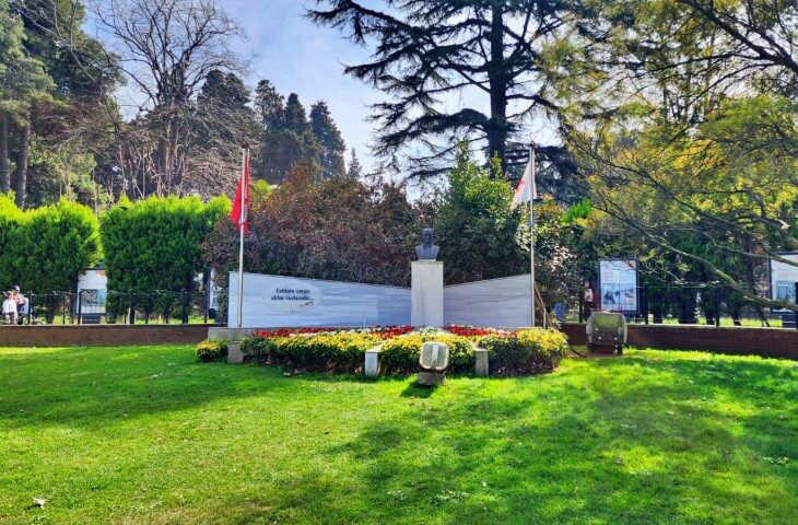 Yürüyen Köşk girişindeki Atatürk büstü ve çevresini süsleyen çiçeklerle düzenlenmiş anıt alanı, bayraklar eşliğinde görülüyor.